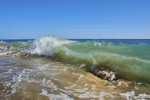 Wave Crashing On Rocky Shore Drucke: Breaking waves on a sandy beach with a rock