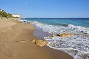 Steep Cliff Landscape Spain Drucke: Breaking waves on a sandy beach with a rock