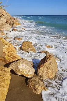 Steep Cliff Overlooking Sea Drucke: Breaking waves on a sandy beach with a view rocks