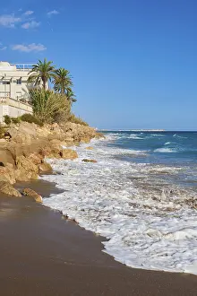 European Coastline Photography Drucke: Breaking waves on a sandy beach with a view rocks