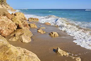Tarragona Coastline Drucke: Breaking waves on a sandy beach with a view rocks
