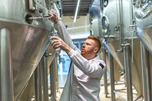 Industrial Building Architecture Design Drucke: Brewery worker performing quality control
