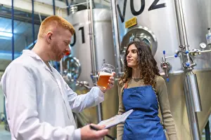 Industrial Building Architecture Drucke: Brewery workers evaluating beer sample for quality control