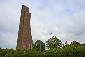 Schleswig Holstein Landmarks Drucke: Brick tower with flags surrounded by vegetation