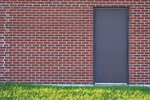 Ontario Canada Landscape Photography Drucke: Brick wall with rectangular door and a meadow in front of it