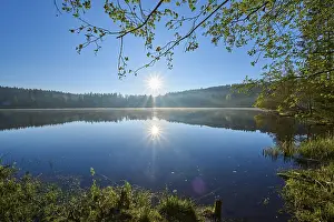 Southern Germany Lakeside View Drucke: A bright sunrise is reflected in a still