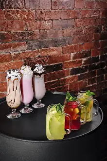 Elegant Table Setting Drucke: Brightly colored beverages are elegantly arranged on a table against a rustic brick wall