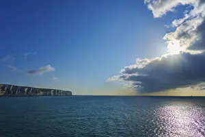 Drucke von Strahlender Sonnenschein durch Wolken über dem Meer und Klippen, Schimmer auf Wasser, Sommer, Kalkklippen, Ärmelkanal, Dover, Kent, England, Großbritannien Dover Drucke: Strahlender Sonnenschein durch Wolken über dem Meer und Klippen.