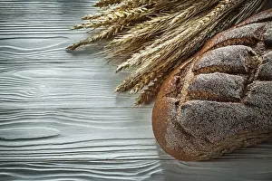 Wholemeal Bread Drucke: Brown bread rye ears on white board top view