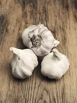 Healthy Eating Concept Image Drucke: Four bulbs of garlic on a rustic kitchen table