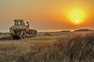 Archeological Excavation Site Drucke: Bulldozer on the beach at sunset