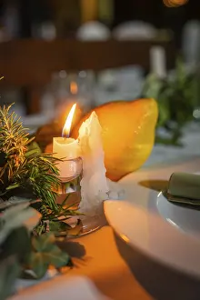 Candlelit Dinner Scene Drucke: A burning candle next to a lemon on a festive table