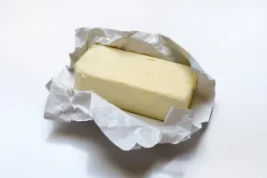 Single Coloured Background Photos Drucke: Butter with opened packaging