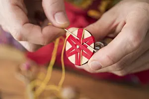 Traditional Crafts Germany Drucke: Button maker stitching and wrapping red and yellow yarn into star pattern