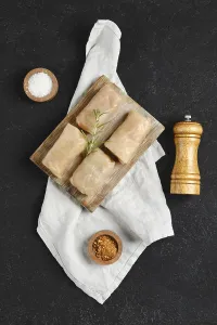 Spicy Herb Seasoning Drucke: Four cabbage spring rolls on a rustic wooden board