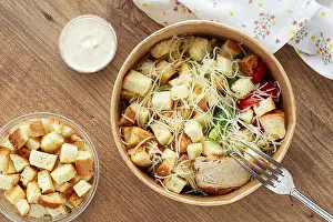Grilled Chicken Meal Drucke: Caesar salad in a paper container