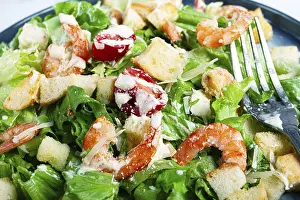High Angle View Of A Dish Drucke: Caesar salad, with shrimp, on a marble background