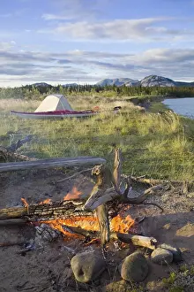 Deserted Riverbank Scene Drucke: Camp fire, evening, tent behind
