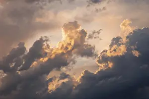 Cloudy Weather Conditions Drucke: A captivating view of dramatic clouds illuminated by the warm glow of a sunset