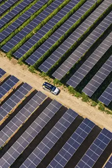 German Farmland Landscape Drucke: A car on a dirt road between rows of solar modules