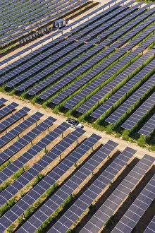 European Renewable Energy Drucke: A car on a path between vast fields of solar panels