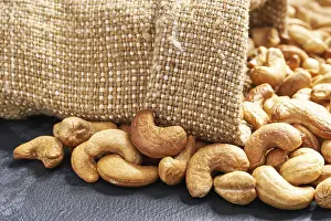 Black Table Setup Drucke: Cashew nuts in a sack of burlap on a black table
