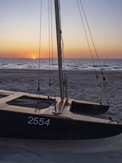 European Coastal Landscape Drucke: A catamaran on the beach at sunset