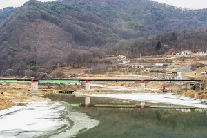 Neuer Brückenneubau über gefrorenen Fluss in ländlicher Berggemeinde.