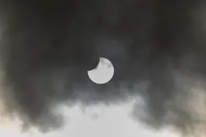 European Weather Forecast Drucke: A partial solar eclipse occurs when the moon eclipses part of the sun and is surrounded by dynamic cloud formations