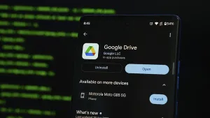 Mobile Phone Technology Drucke: Smartphone displaying Google Drive app interface against a coding background
