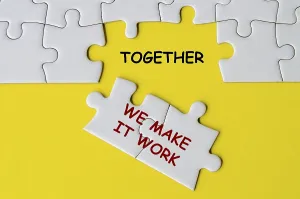 Team Collaboration Concept Drucke: Together We Make It Work text on missing jigsaw puzzle representing teamwork and unity