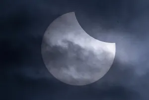 Clouds And Sunlight Drucke: Partial solar eclipse with clouds in the sky
