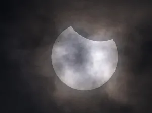Teilweiser Sonnenfinsternis mit Wolken im Himmel.