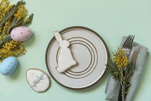 Easter Dinner Table Setting Drucke: Table setting for Easter dinner with easter eggs and mimosa on a pastel background