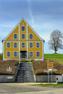 Bilder Datiert 21. März 2024: Katholische Pfarrhaus, gelbe Fassade und kahler Baum.
