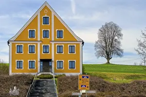 Bilder Datiert 21. März 2024: Katholische Pfarrhaus, gelbe Fassade und kahler Baum.