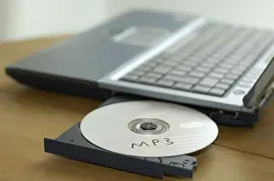 Computer Crime Drucke: CD labeled MP3 in the CD-Drive of a notebook