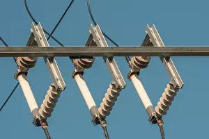 Power Industry Equipment Drucke: Ceramic eletric insulators outside on the sky background