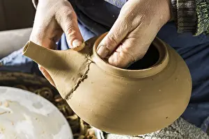 Handcrafted Goods Europe Drucke: Ceramic workshop, hands checking fit of spout on pot