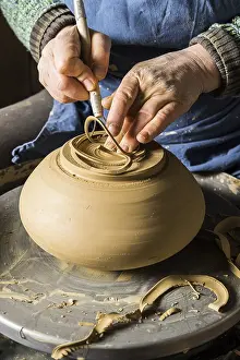 Handmade Ceramic Art Drucke: Ceramic workshop, hands shape bottom of pot on pottery wheel