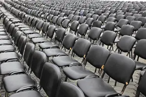 Empty Chair Rows Drucke: Chairs covered with gray plastic stand in rows in a function room