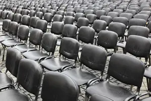 Empty Chair Rows Drucke: Chairs covered with gray plastic stand in rows in a function room
