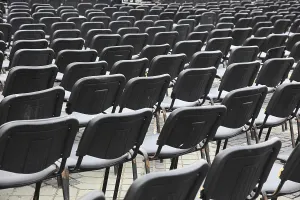 Empty Chair Rows Drucke: Chairs covered with gray plastic stand in rows in a function room