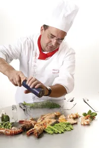 Riesengarnele Drucke: Koch fügt Pfeffer auf einem Teppan-Grill hinzu.