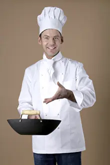 Studio Shot Of Cook Drucke: Chef gesturing to wok in his hand