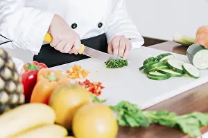 White Background Still Life Drucke: Chef hands preparing and cutting vegetables