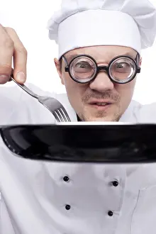 Food Preparation Studio Shot Drucke: Chef holding pan and fork isolated on white background
