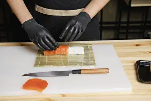 Fresh Sushi Rolls Drucke: Chef puts salmon while preparing rolls