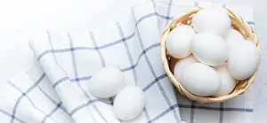 Fresh Chicken Eggs Drucke: Chicken eggs on a checked kitchen towel on a light table