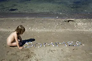Waterfront Recreation Drucke: Child playing with shells on the beach